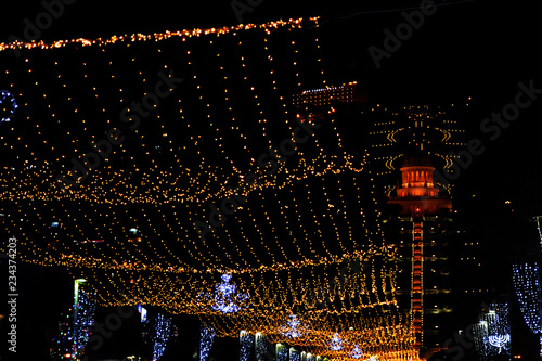 Bright lights on Ben Gurion street of Haifa city in Israel, view of the Bahai temple. hanging garlands and festive decorations of the night city for the New Year. photo