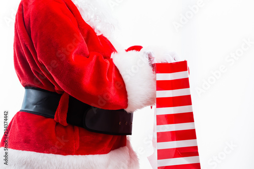 Santa holding a shopping bag isolated on white background © Tierney