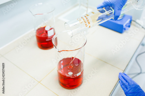 Εκτύπωση καμβά Hands of the scientist in the laboratory mixes with transfusion a chemical materials from graduated cylinder to beaker