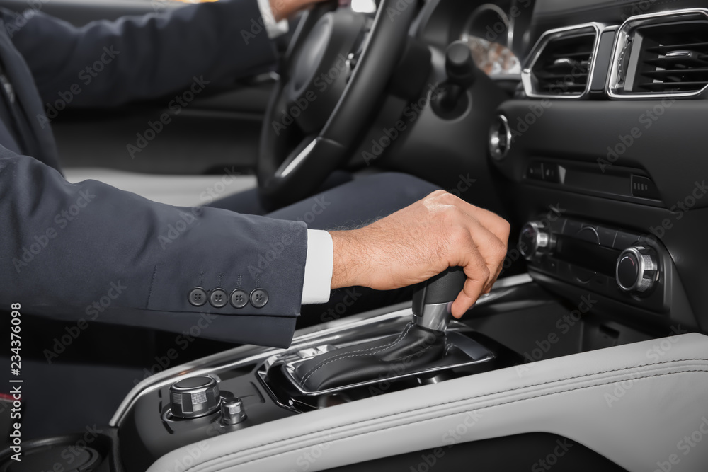 Man holding hand on gear lever in modern car, closeup