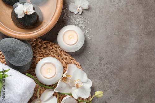 Flat lay composition with spa stones and candles on gray background. Space for text