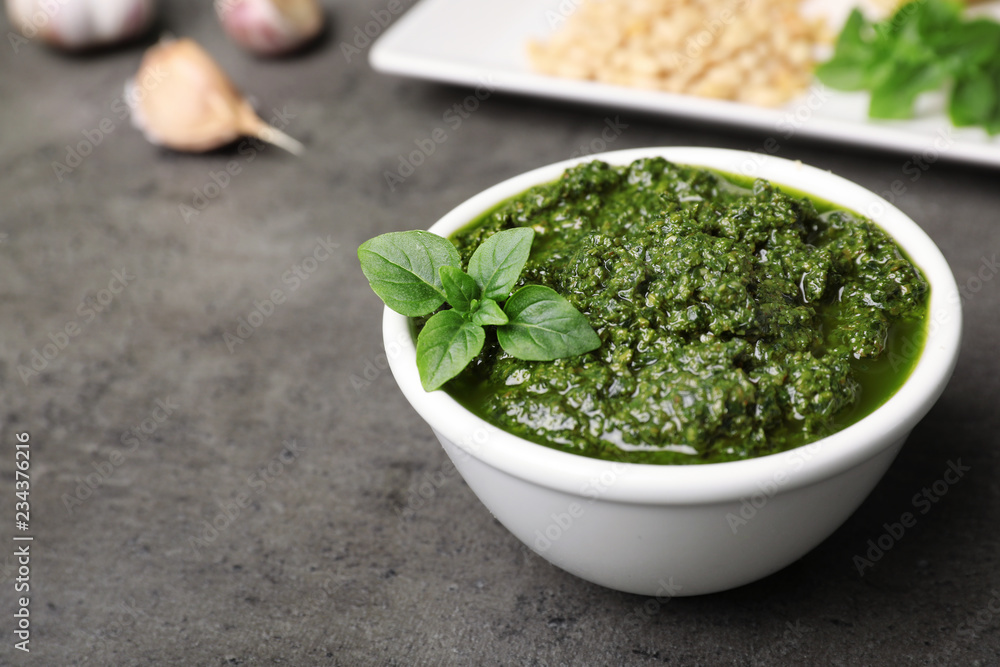 Homemade basil pesto sauce in bowl on table. Space for text Homemade basil pesto sauce in bowl on table. Space for text