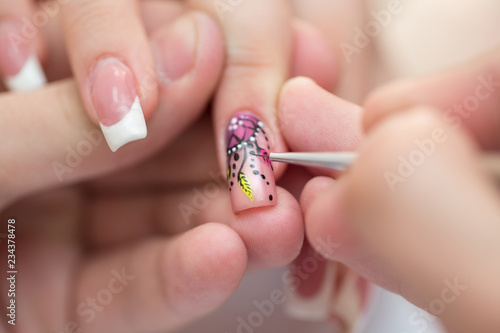 Closeup shot man making manicure to woman in beauty salon photo
