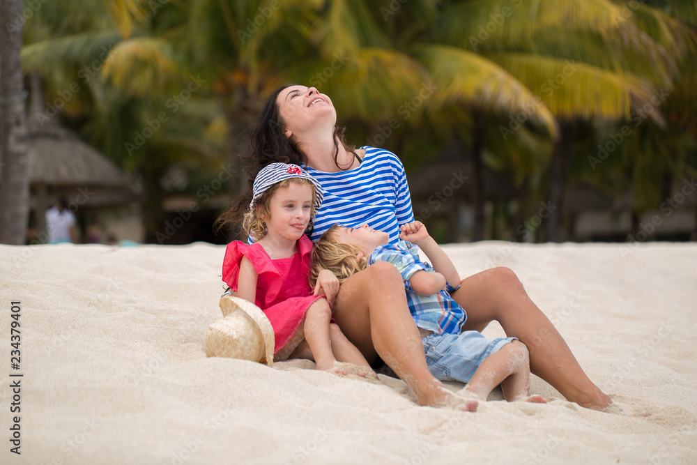 Beautiful mother and two kids enjoying beach vacation