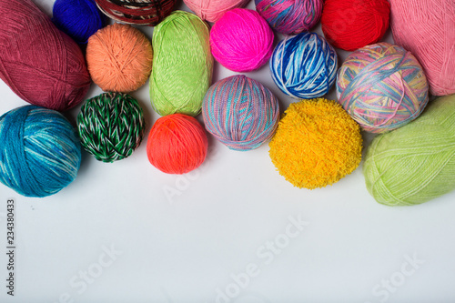 Balls of colored yarn. View from above. All the colors of the rainbow. Sample knit. Crochet.
