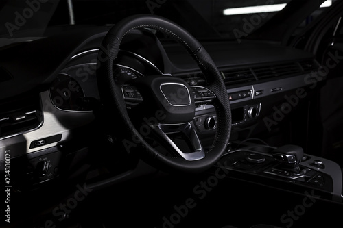 Interior of luxury suv car with black leather steering wheel and shift gear. Alcantara cockpit seats and doors. Black dashboard.