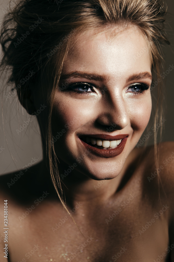 Art portrait of a beautiful girl with make-up, clean skin and flowing hair.