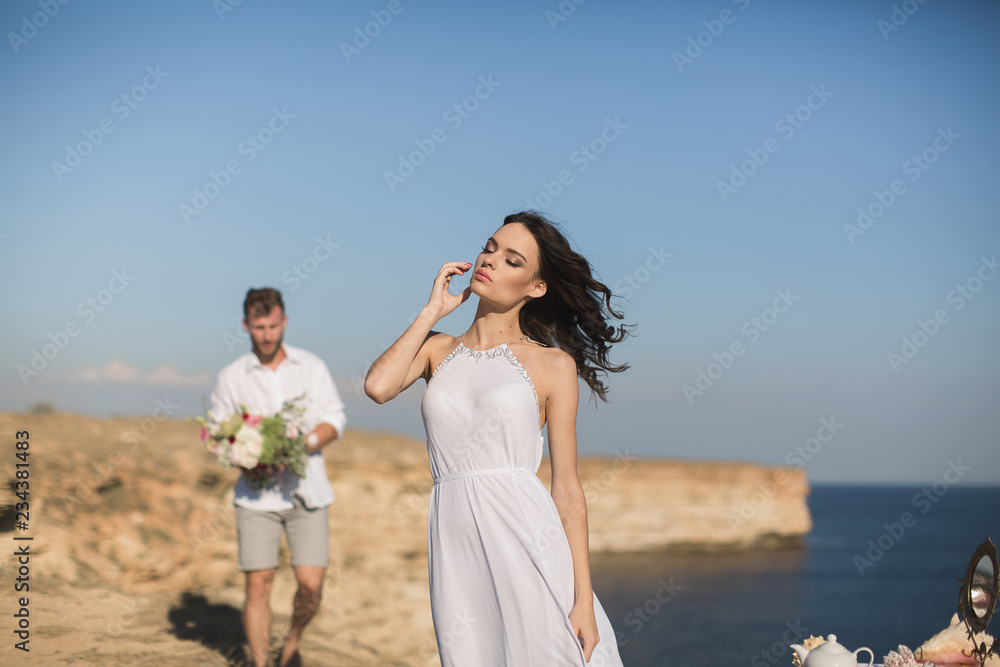 Beautiful young couple on a date. The guy brings flowers. Beautiful young couple on a date. The guy brings flowers.