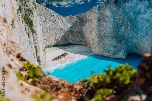 Famous shipwreck on Navagio beach with turquoise blue sea water surrounded by huge white cliffs. Famous landmark location on Zakynthos island, Greece. Nature framed