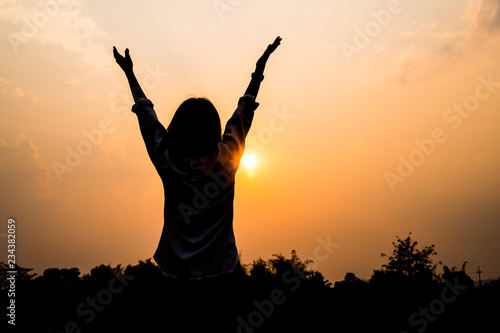 People freedom style Concept : Silhouette of Asian Young woman relaxing, Strong confidence open her arms and watching sunset scene in summer sunset sky outdoor