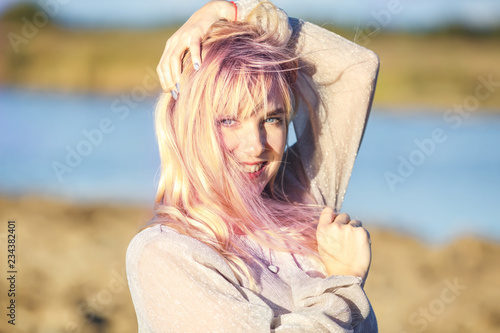 Outdoor close up portrait beautiful blonde girl with youth and skin care attractive looking at camera. Light key