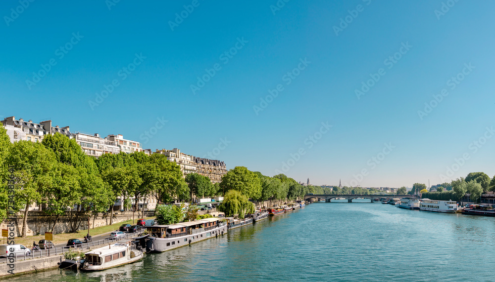Manned barges moored to the coast of Seine river in Paris