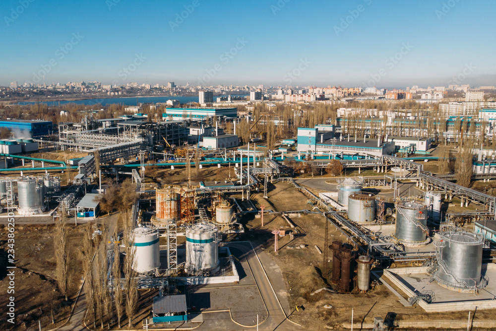 Aerial view of industrial factory or plant buildings with steel storage construction tanks and pipes, oil refinery and chemical manufacturing concept