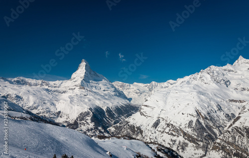 Majestic Matterhorn mountain in front of a blue sky.