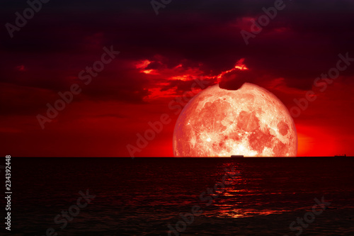 half red blood moon on night sea and back silhouette red cloud