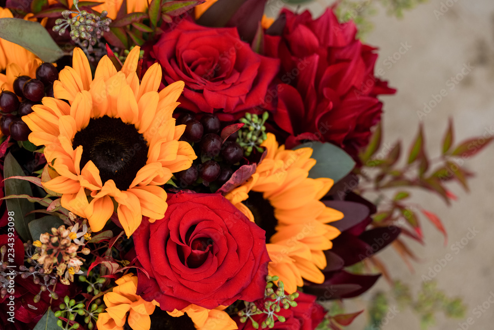 Fototapeta premium bright and colorful wedding bouquet with red roses and yellow sunflowers