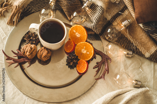Christmas still life with cup with tea or coffee, cookies in the shape of snowflakes, oranges with christmas decorations and nuts