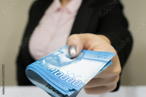 Photos Close-up business woman wearing suit holding chilean money notes