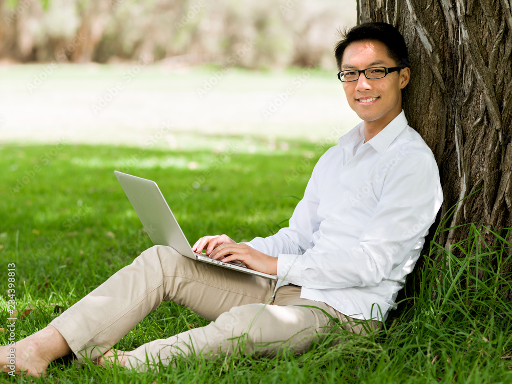 Young businessman using laptop while sitting outdoors Young businessman using laptop while sitting outdoors