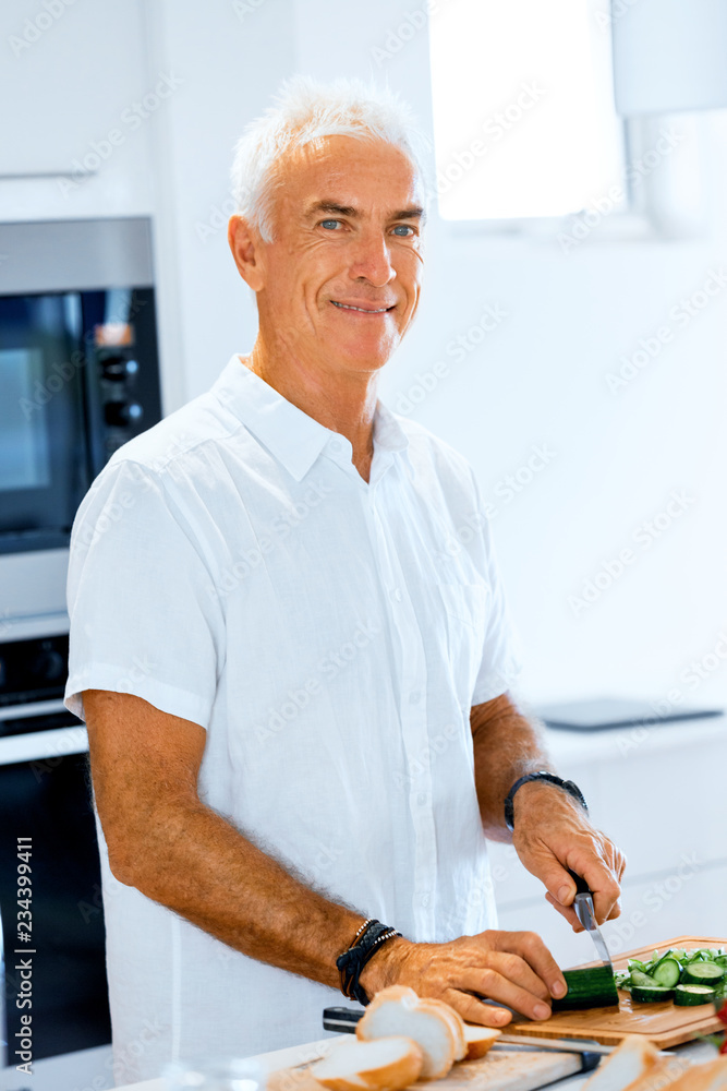 Portrait of a smart senior man standing in kitchen Portrait of a smart senior man standing in kitchen