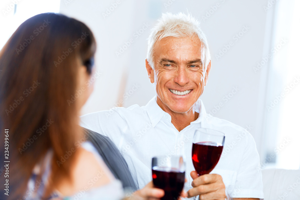 Senior man with holding a glass of wine indoors Senior man with holding a glass of wine indoors