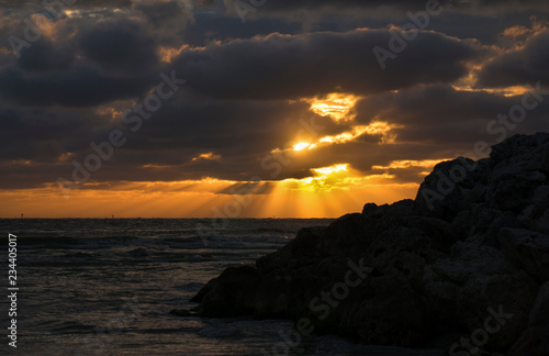 Beautiful photo of sunset on the Gulf of Mexico with the silhouette of a rock outcropping.