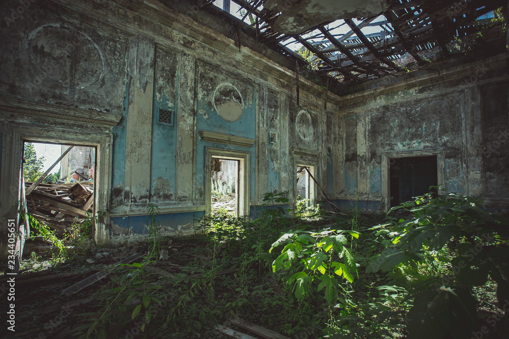 Ruined mansion hall interior overgrown by plants. Nature and abandoned architecture, green post-apocalyptic concept