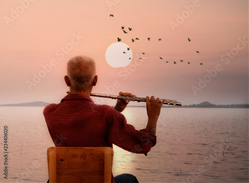 Canvas-taulu Man playing flute with sunset or sunrise background