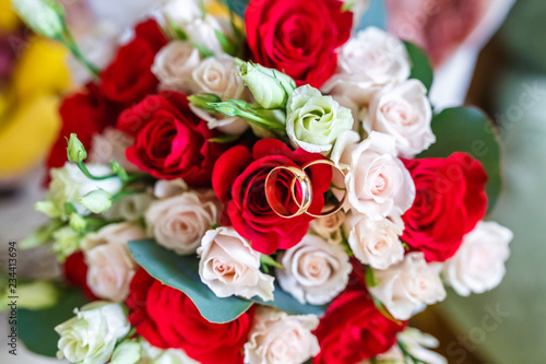 bright wedding bouquet of summer red and white roses with rings
