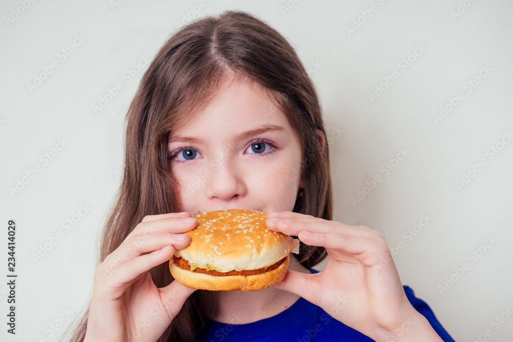 beautiful teenager girl is eating baked vegetarian burger with vegetables. Child vegan idea healthy eating concept.clear skin perfect teen acne refusal from junk food