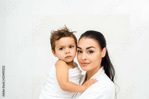 Close up of mother holding toddler son on white