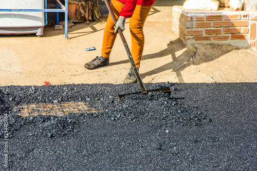 workers are leveling asphalt on construction site.