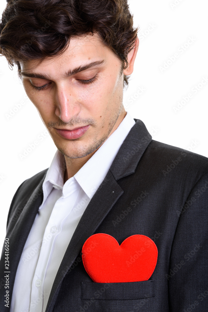 Close up of young handsome businessman looking at red heart on c Close up of young handsome businessman looking at red heart on c