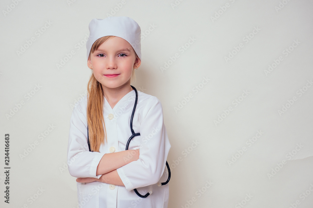 Adorable child girl uniformed as doctor wearing doctor's cap and glasses with stethoscope on white background.Happy kid little female doctor career guidance dreaming about future profession Adorable child girl uniformed as doctor wearing doctor's cap and glasses with stethoscope on white background.Happy kid little female doctor career guidance dreaming about future profession