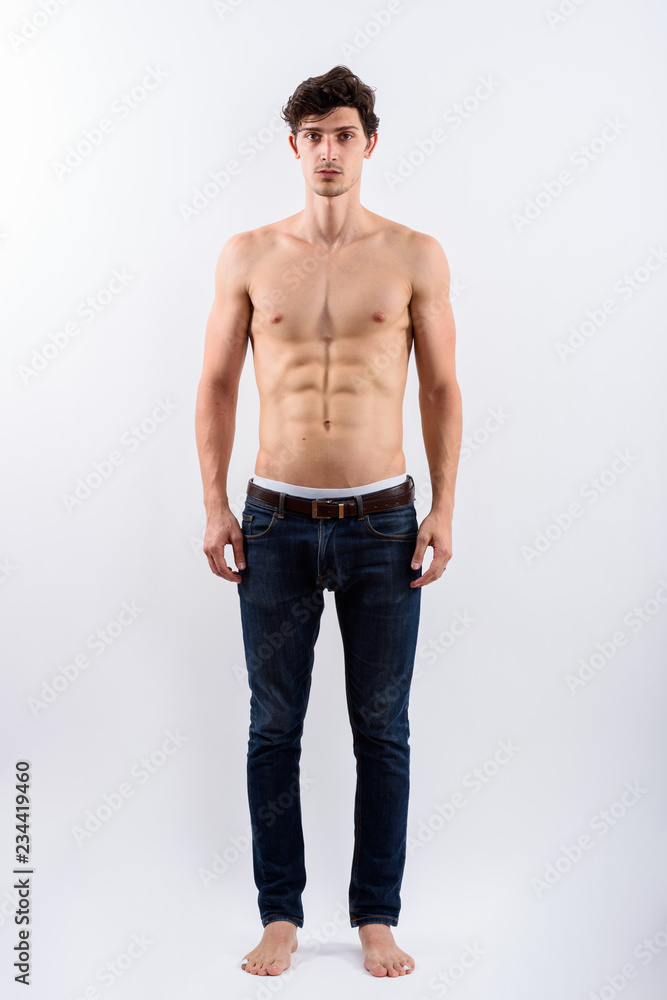 Full body shot of young handsome man standing shirtless