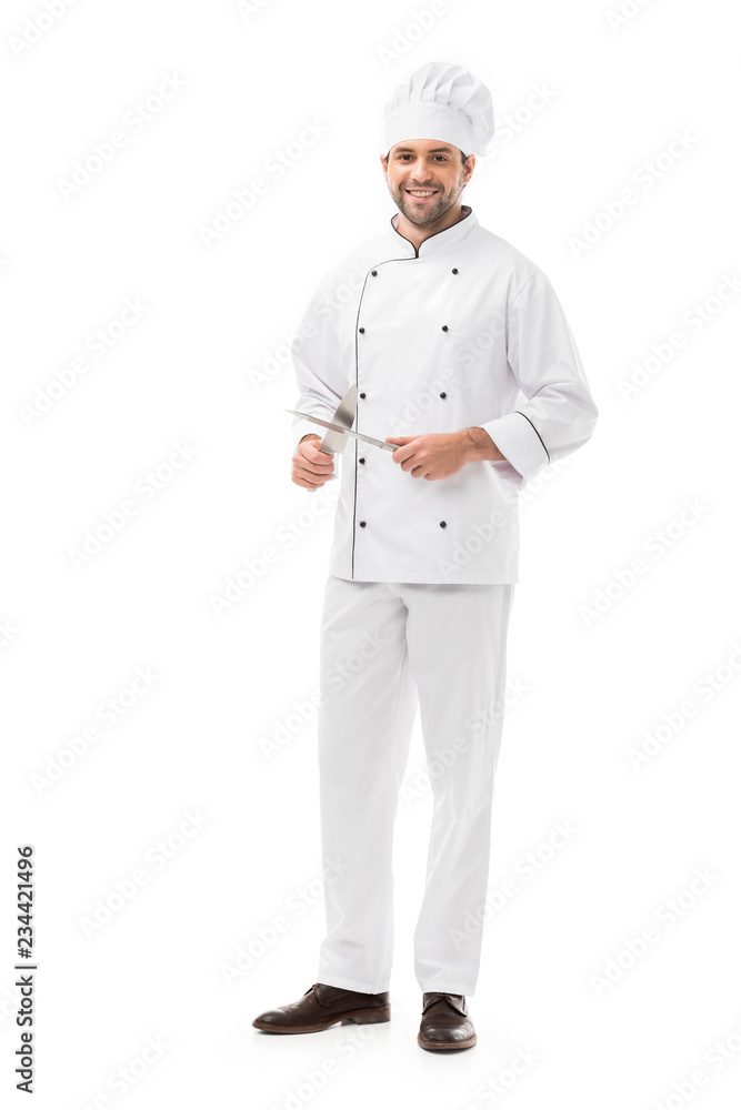 happy young chef holding cutting knives and looking at camera isolated on white happy young chef holding cutting knives and looking at camera isolated on white
