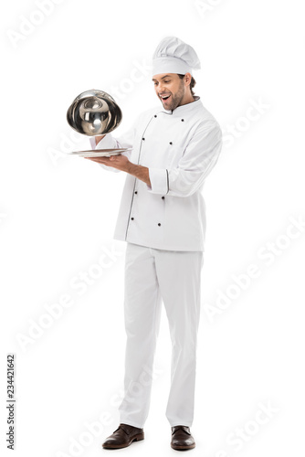 expressed young chef taking of serving dome from plate isolated on white