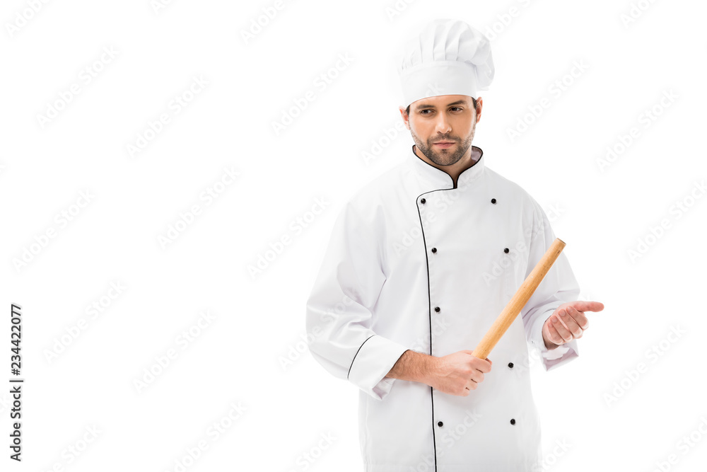 serious young chef holding rolling pin isolated on white serious young chef holding rolling pin isolated on white