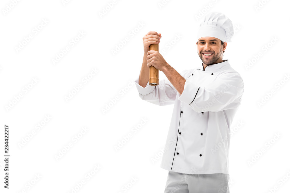 smiling young chef using bamboo pepper mill isolated on white