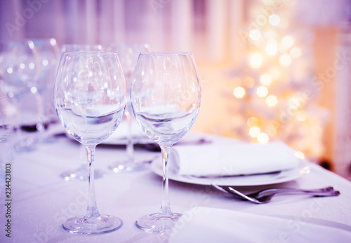 Beautiful Christmas table set. Wine glasses on celebration party