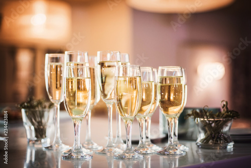 Champagne wine into wine glasses. Champagne flutes on a wedding reception or on celebration party 