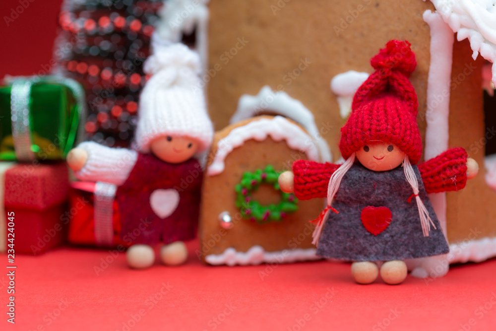 Cookie house with dolls and christmas tree on red background Cookie house with dolls and christmas tree on red background
