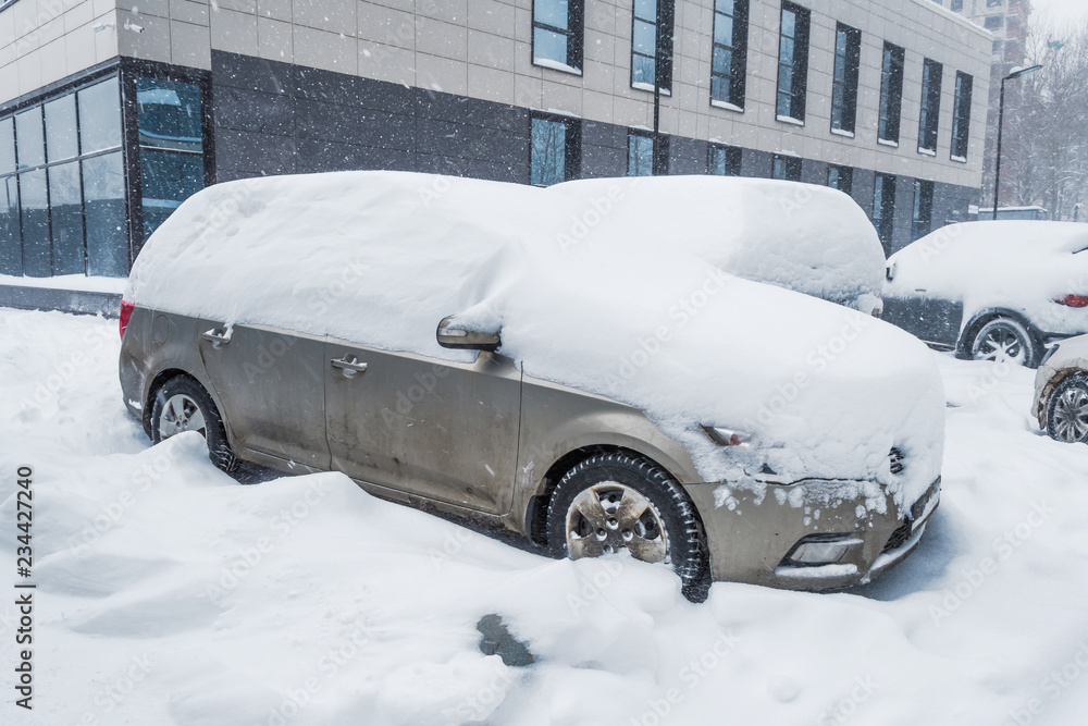 Car covered with snow during a snowstorm in winter. Car covered with snow during a snowstorm in winter.