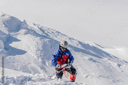 Extreme winter sports: climber at the top of a snowy peak . Concepts: determination, success, brave.