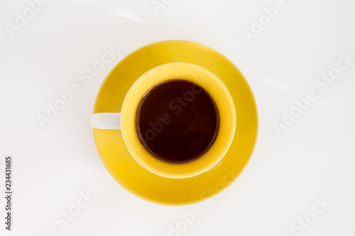 some coffee (espresso) in yellow cup on the yellow saucer on top isolated