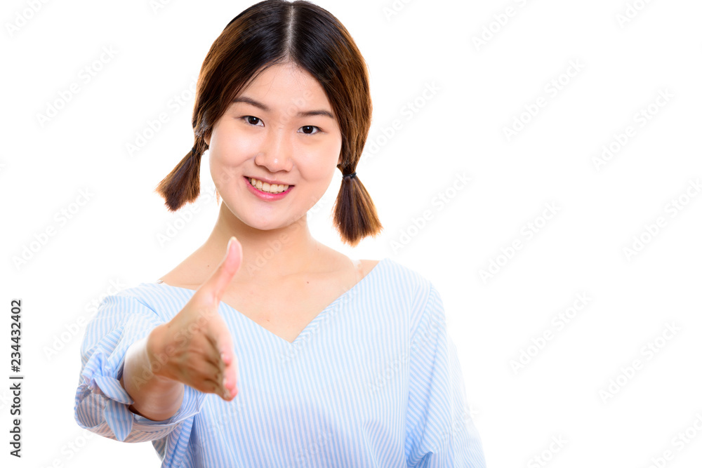 Studio shot of young happy Asian woman smiling while giving hand Studio shot of young happy Asian woman smiling while giving hand