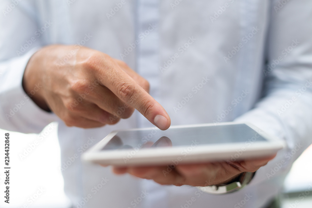 Close-up of marketing specialist analyzing data online while using digital tablet. Unrecognizable businessman pointing at gadget display. Information concept Close-up of marketing specialist analyzing data online while using digital tablet. Unrecognizable businessman pointing at gadget display. Information concept