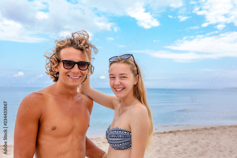 Smiling playful young couple in love having fun at sandy beach. Smiling playful young couple in love having fun at sandy beach.