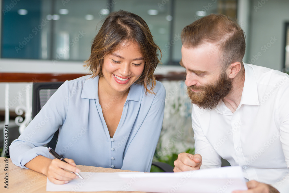 Happy managers satisfied with sales result. Two office employees studying and discussing reports and smiling. Report and profit concept Happy managers satisfied with sales result. Two office employees studying and discussing reports and smiling. Report and profit concept