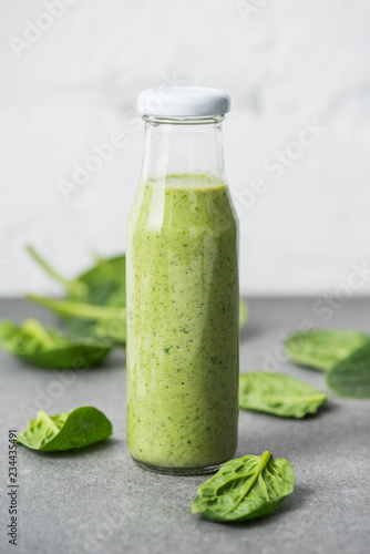 Green blended organic smoothie in glass bottle